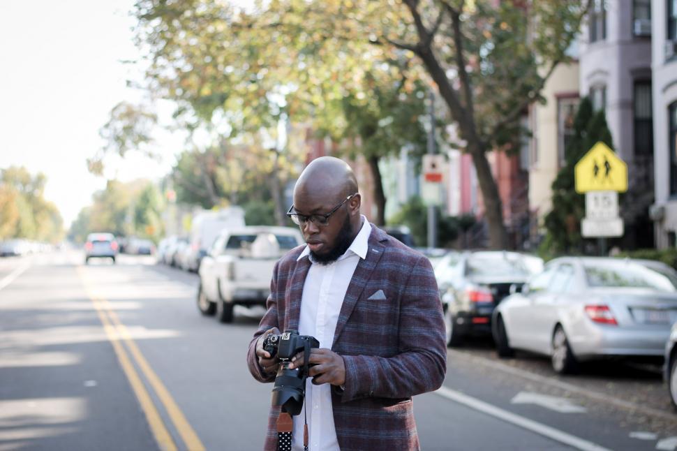 Free Image of Young man in glasses and blazer with professional camera 