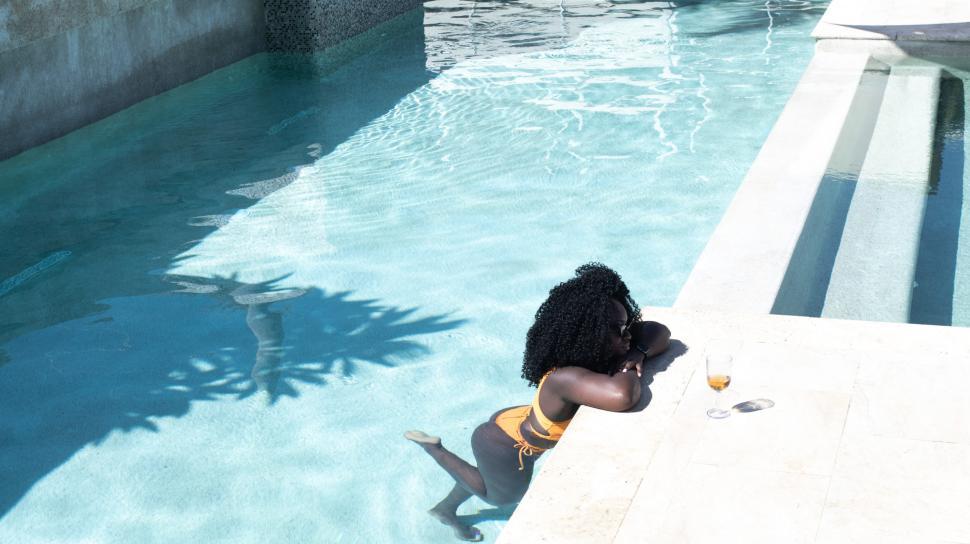 Free Image of Young Woman with curly hair in Swimming Pool 