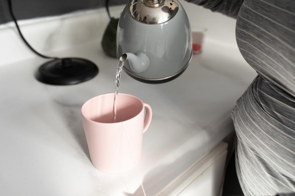 Free Image of Unrecognizable Woman Hand With Teacup and Kettle 