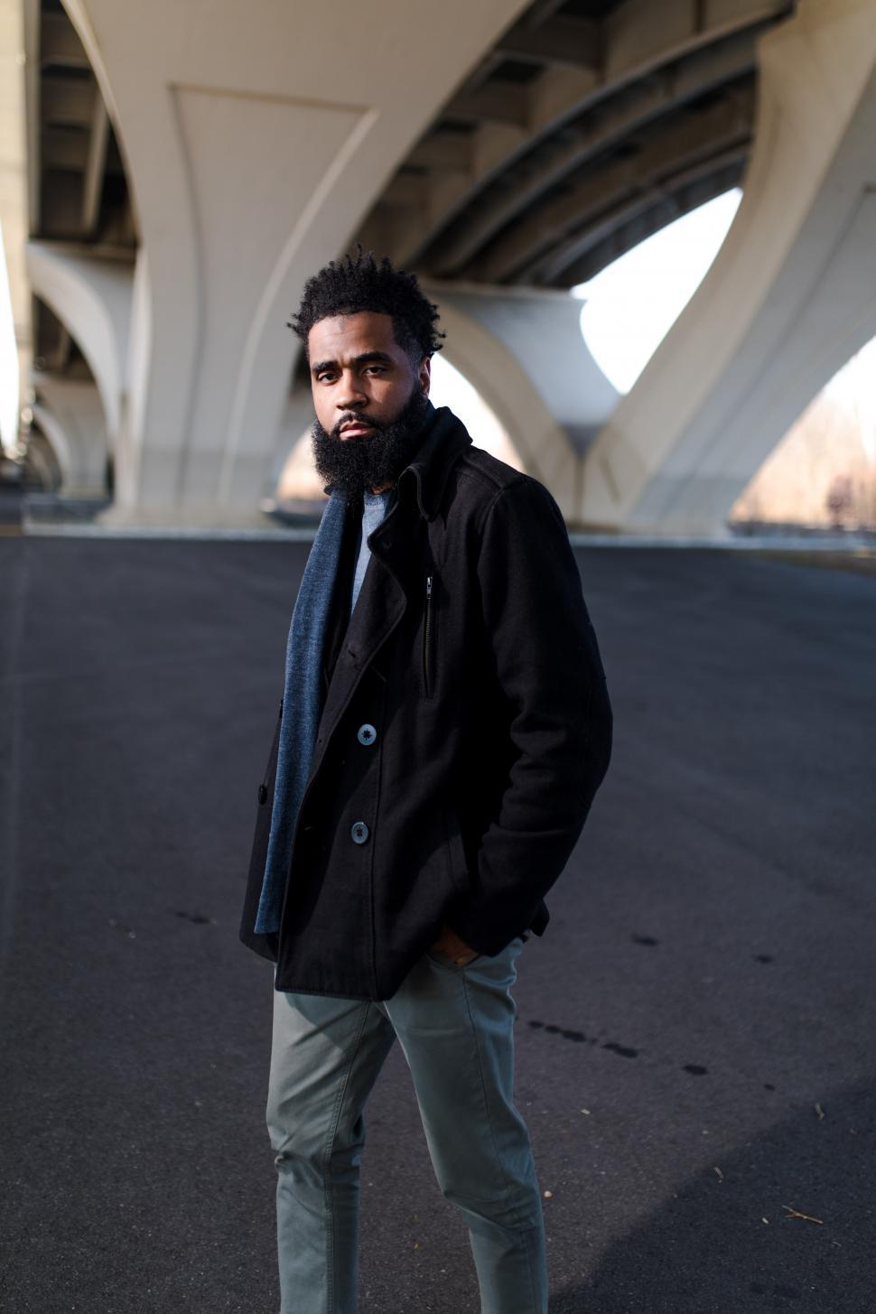 Free Image of Young Man in Black Jacket with concrete bridge 