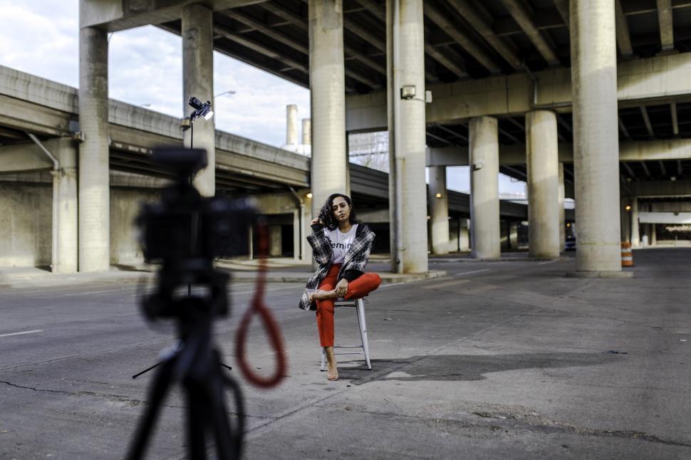 Free Image of Young Female Fashion Model in Red Trousers with camera and tripo 