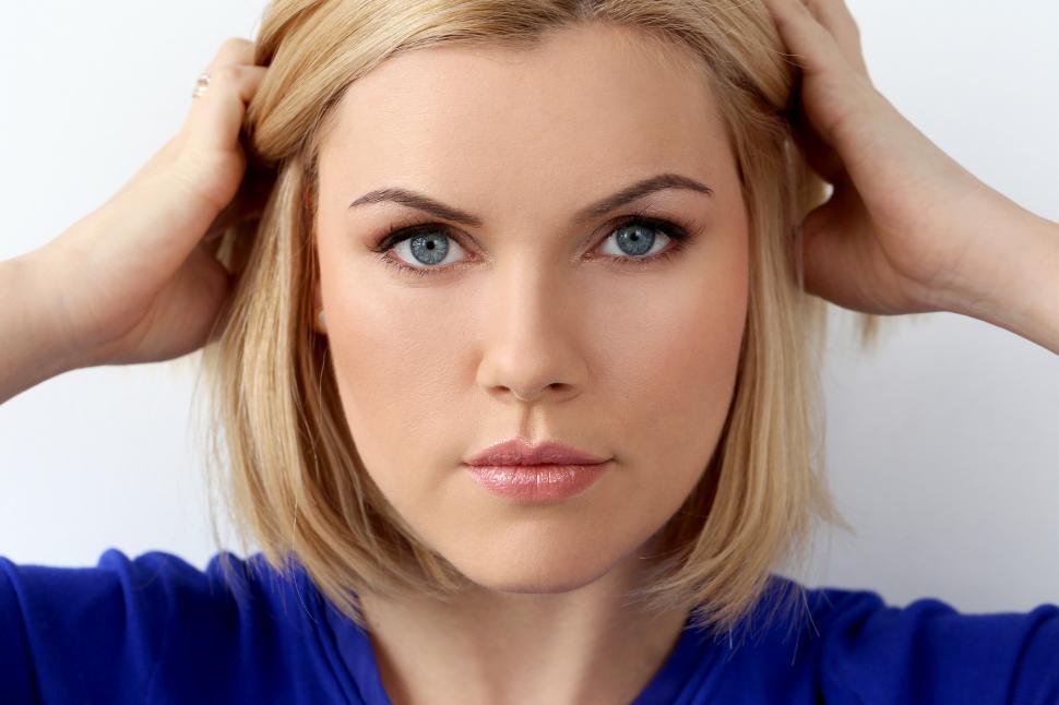 Portrait of a beautiful girl with big blue eyes looking at camera with  surprised expression - a Royalty Free Stock Photo from Photocase