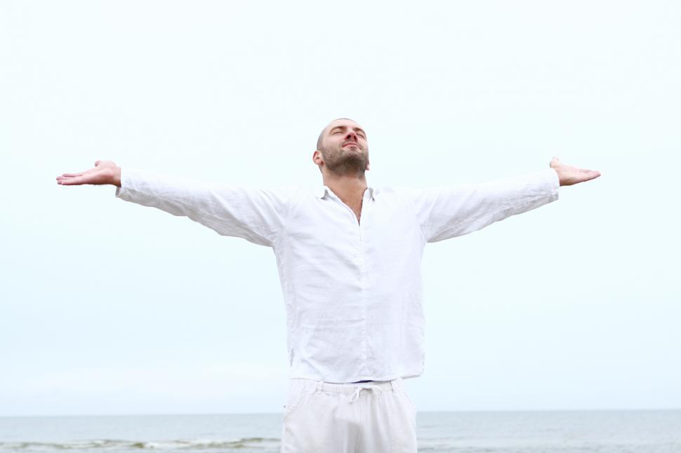 Free Image of Man on the beach with arms spread 