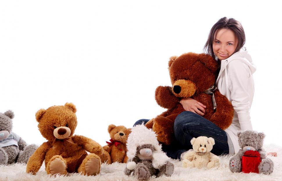 Young woman embracing teddy bear while city in background stock photo