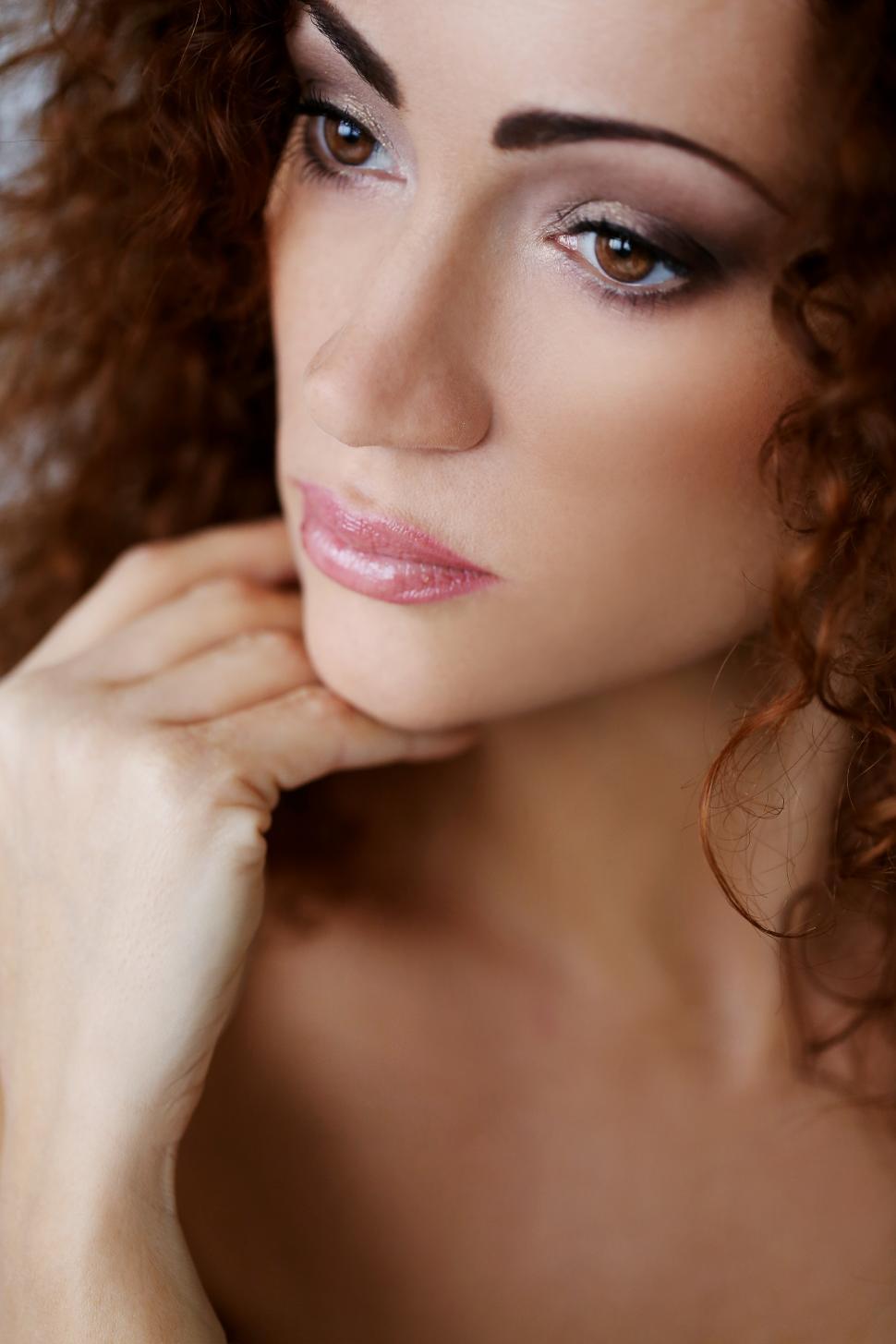 Free Image of Woman with dark hair and dark eyes, chin on hand 