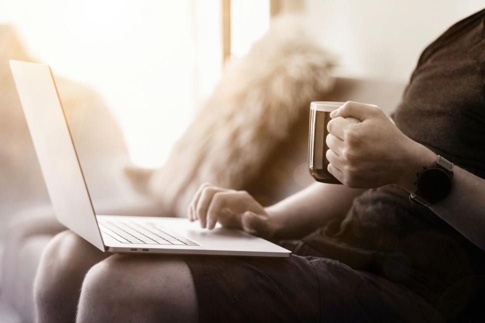 work-from-home--person-with-coffee-in-hand-working-on-couch.jpg