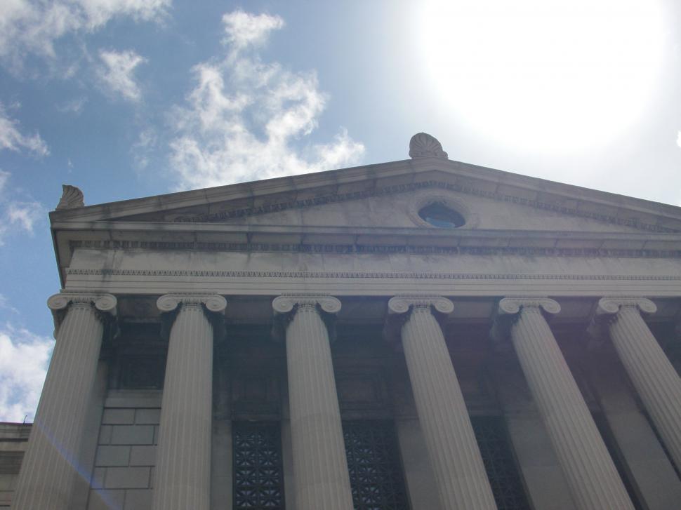 Free Image of Tall Building With Columns Against Sky Background 