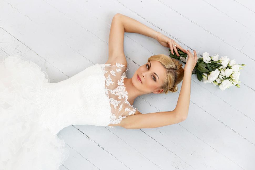 Free Image of Wedding. Beautiful bride with flowers on floorboards 