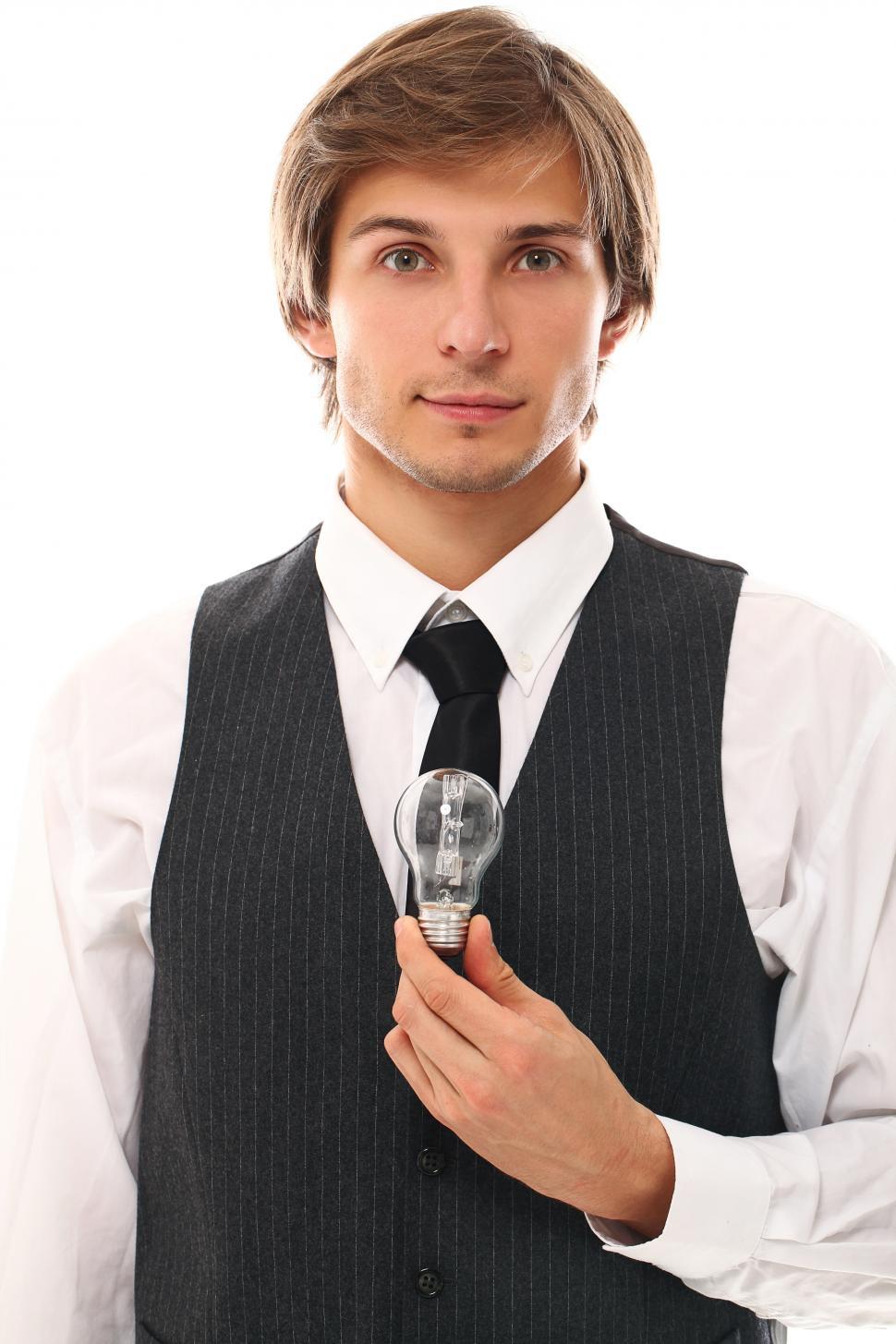 Free Image of Idea. Well dressed man holding a light bulb. 