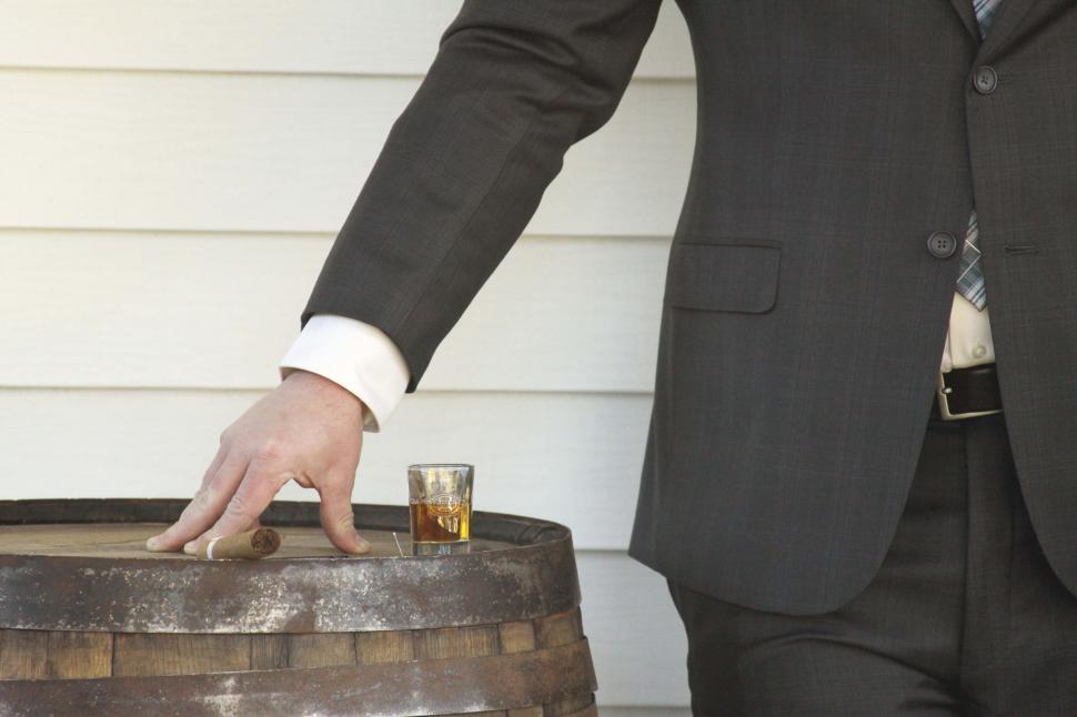 Business man hand with glass of whiskey and cigar