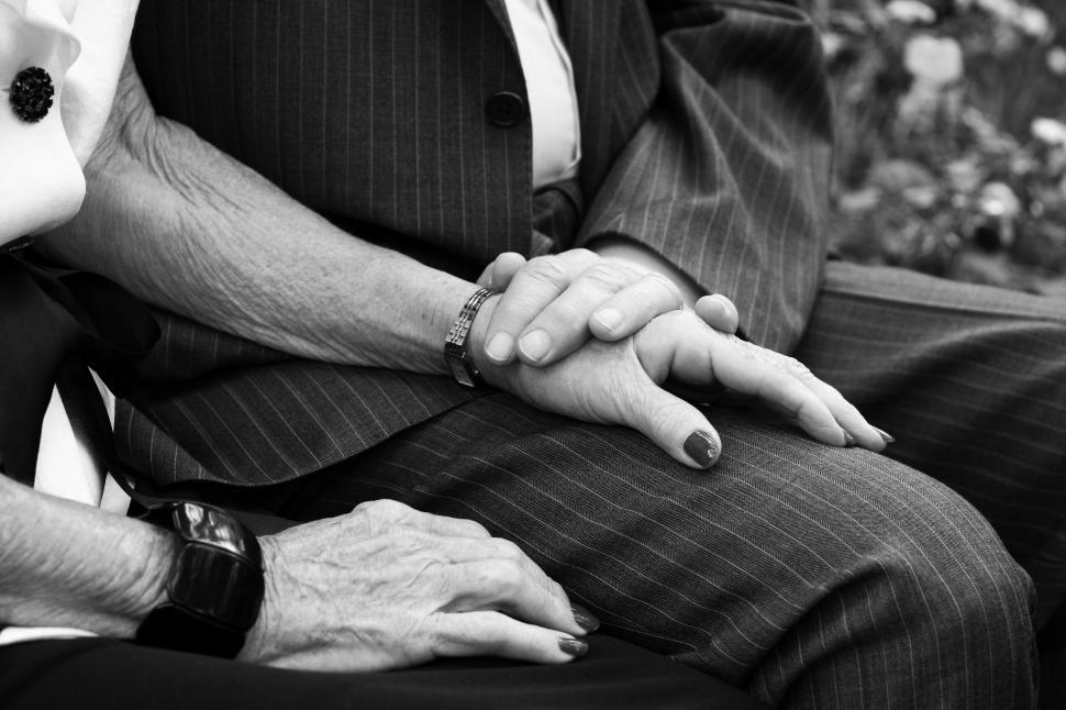 elderly couple holding hands