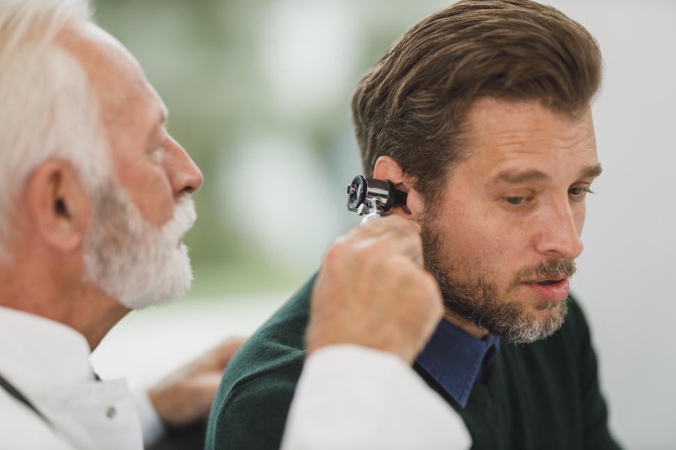 Free Stock Photo of Doctor examining the ear of man with instrument