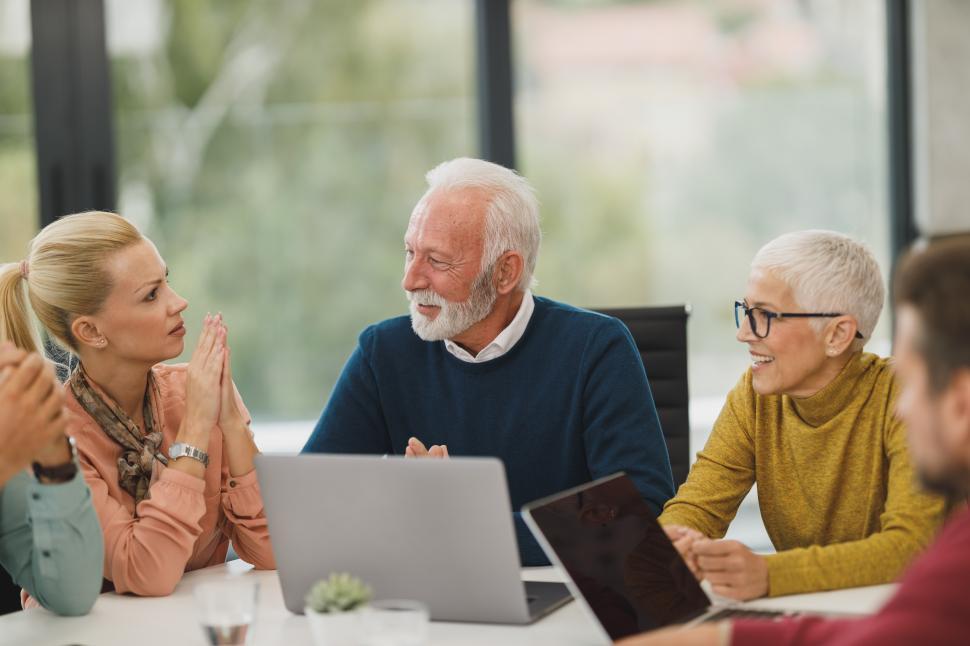 Free Image of Office workers discussing in a meeting with laptops on table 