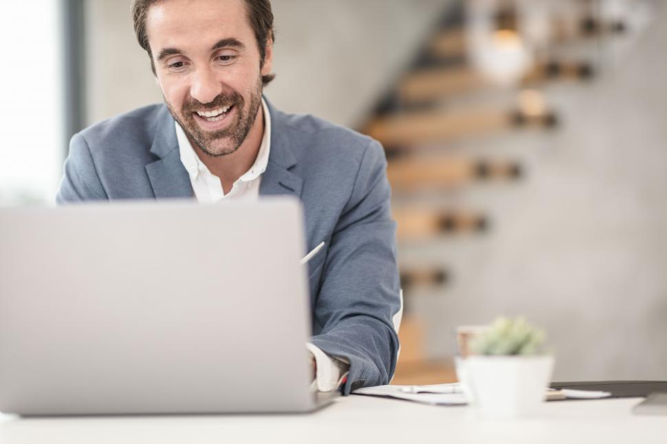 happy male professional looking at laptop