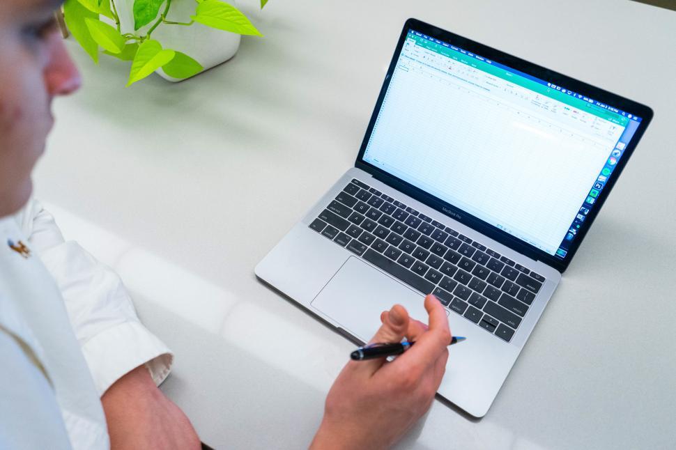 Free Image of Young man with laptop and plant on table in office 