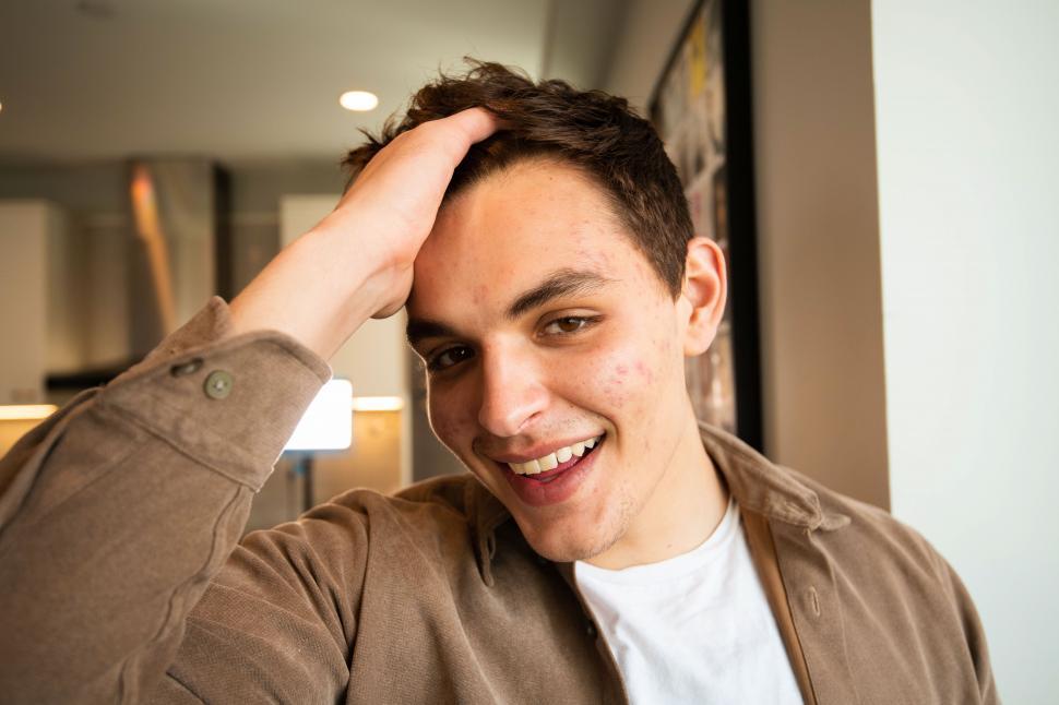 Free Image of Happy man with hand in hair 