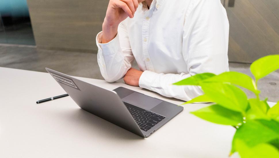 Free Image of Man with laptop and pen on table 