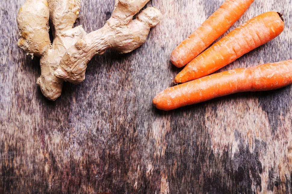 Free Image of Carrots and ginger root on textured table 