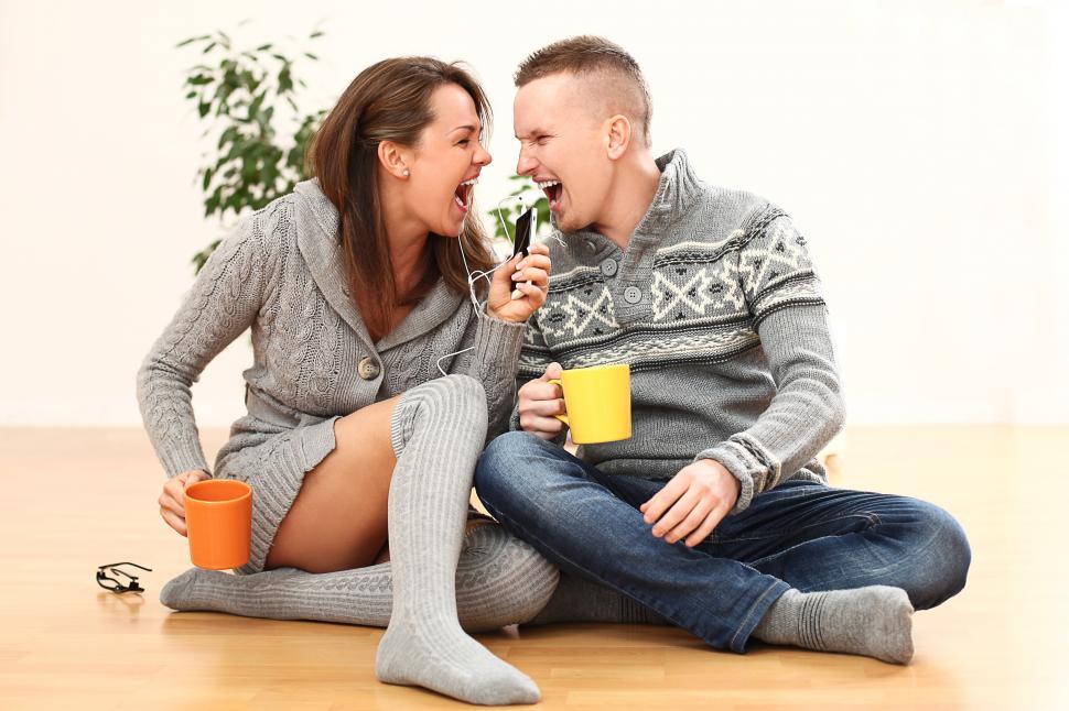 Free Image of Young couple rock out to mobile device music 
