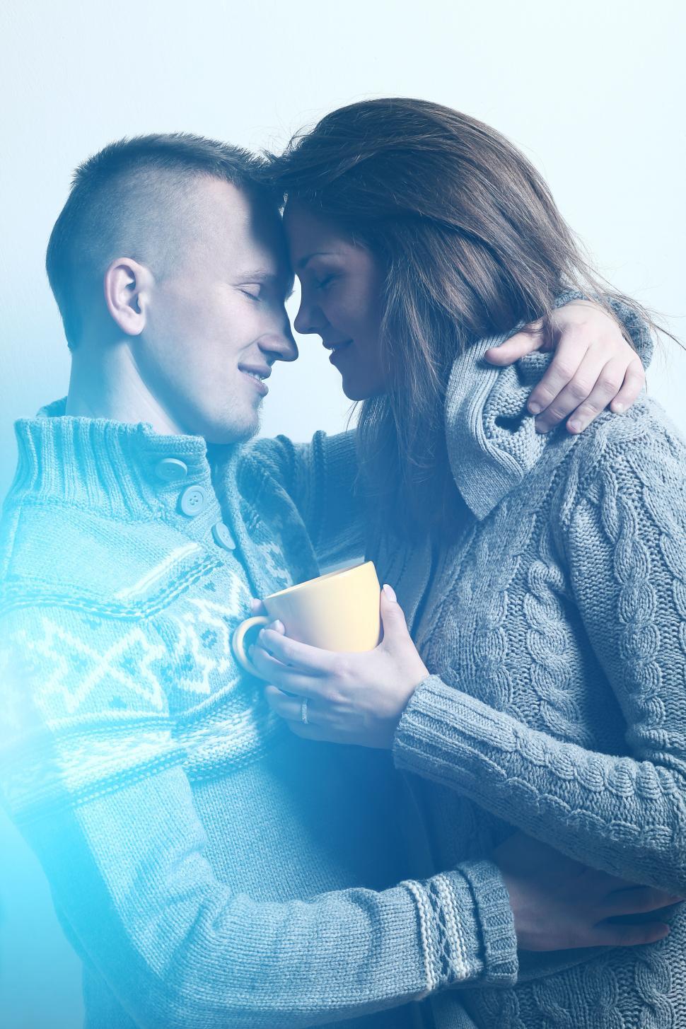 Young couple embrace, blue tined light