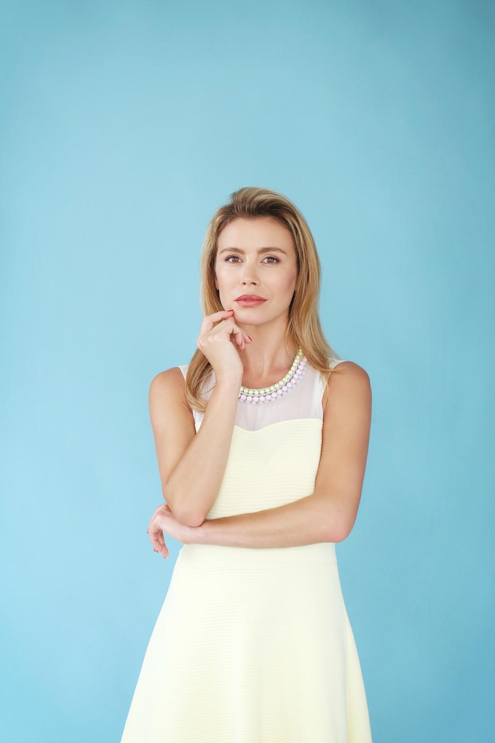 Free Image of Beautiful woman standing against a blue background 