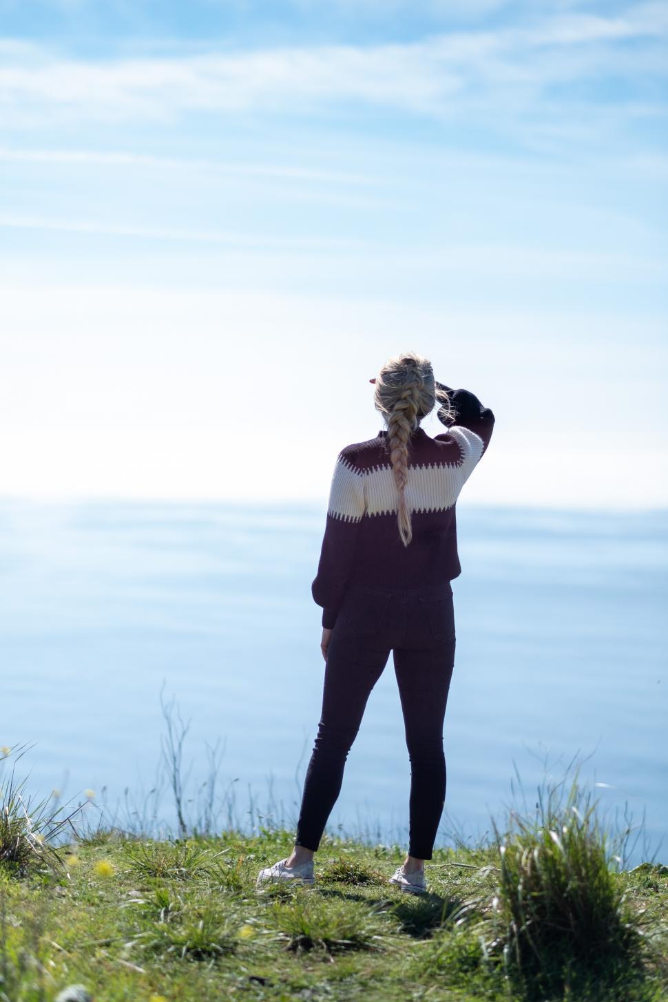 Free Image of Backside view of woman at the shoreline with ocean 