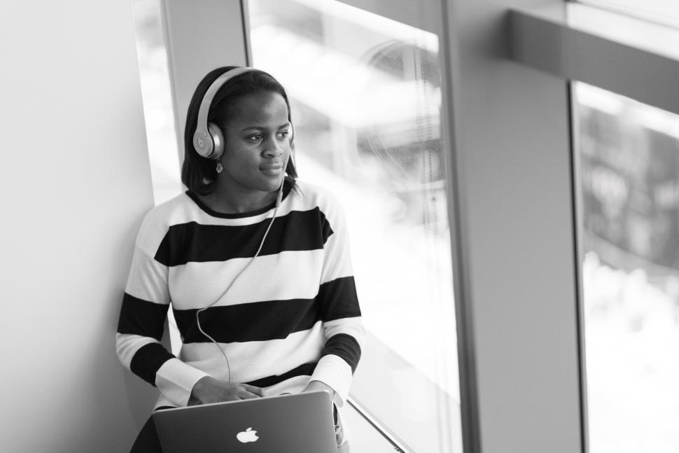 Free Image of Female using laptop with headphones - looking away 