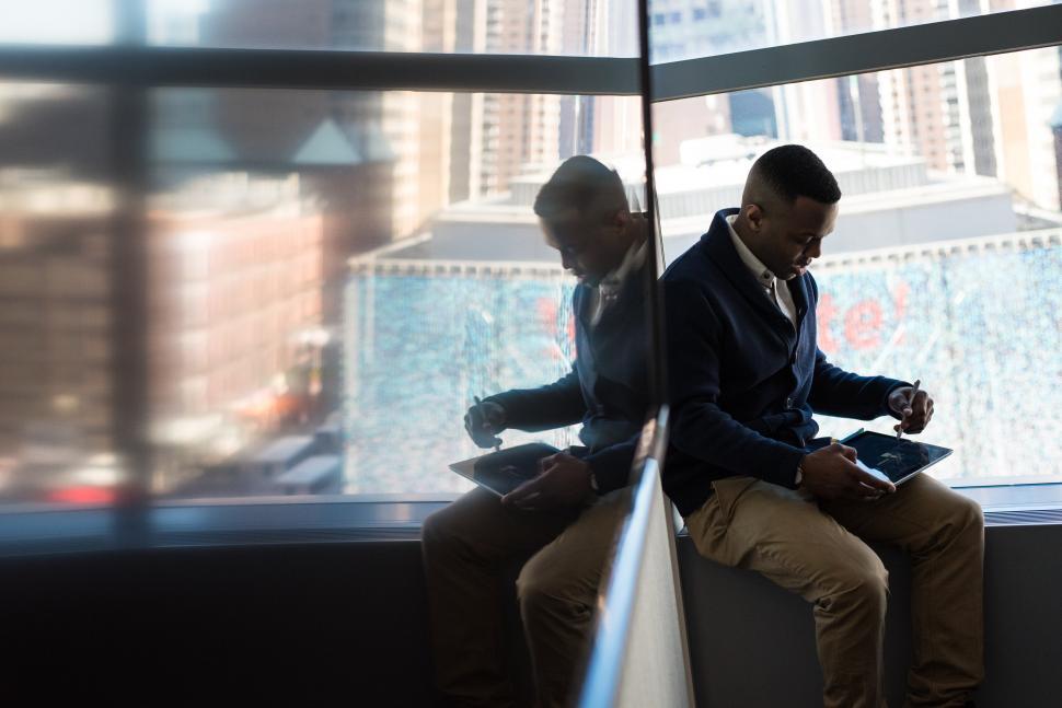 Free Stock Photo of Young Man sitting near window