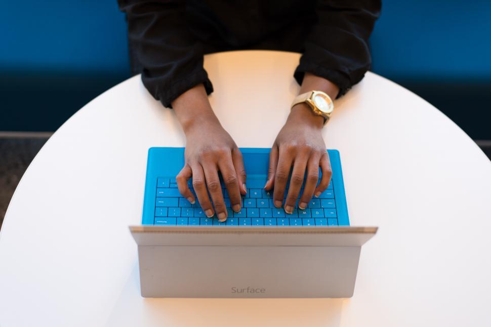 Free Image of Hands typing on blue laptop 