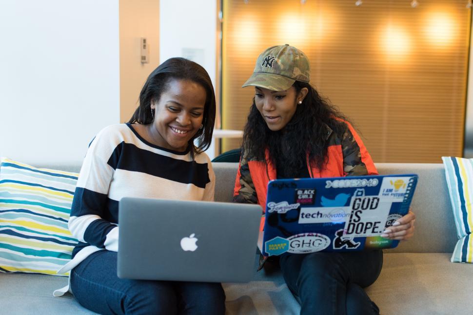 Free Image of Happy businesswomen with laptops on couch 