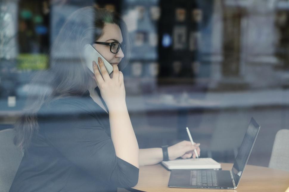Free Image of Woman on the phone, through window 