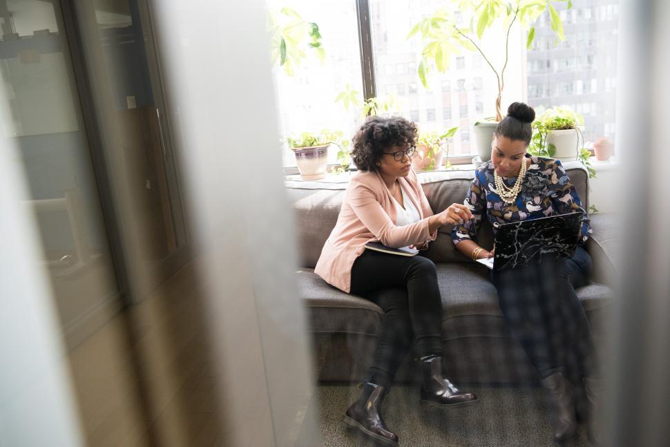 Free Image of Stylish female colleagues with laptop on couch 