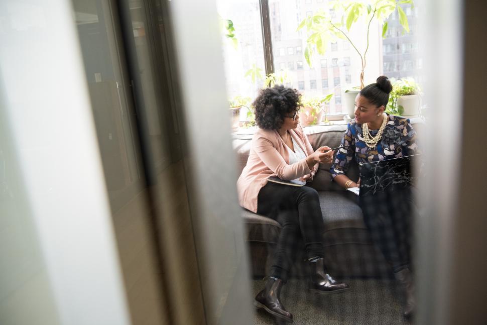Free Image of Stylish female colleagues with laptop on couch 