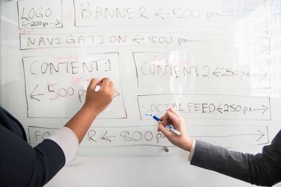 Free Image of Two business women hands with marker pen and whiteboard 