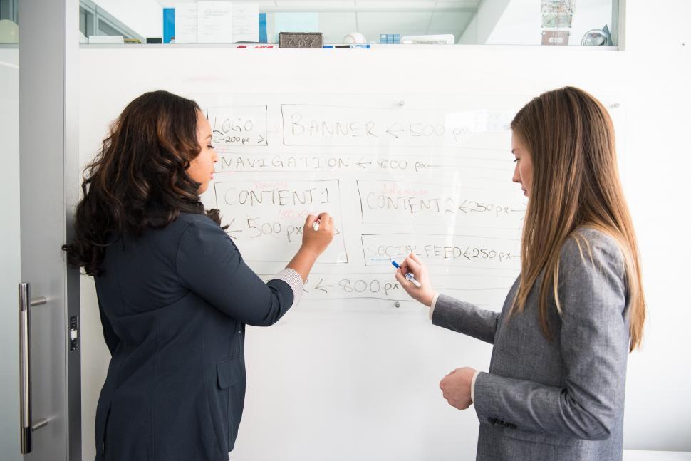 Free Image of Two business women with marker pen and whiteboard 