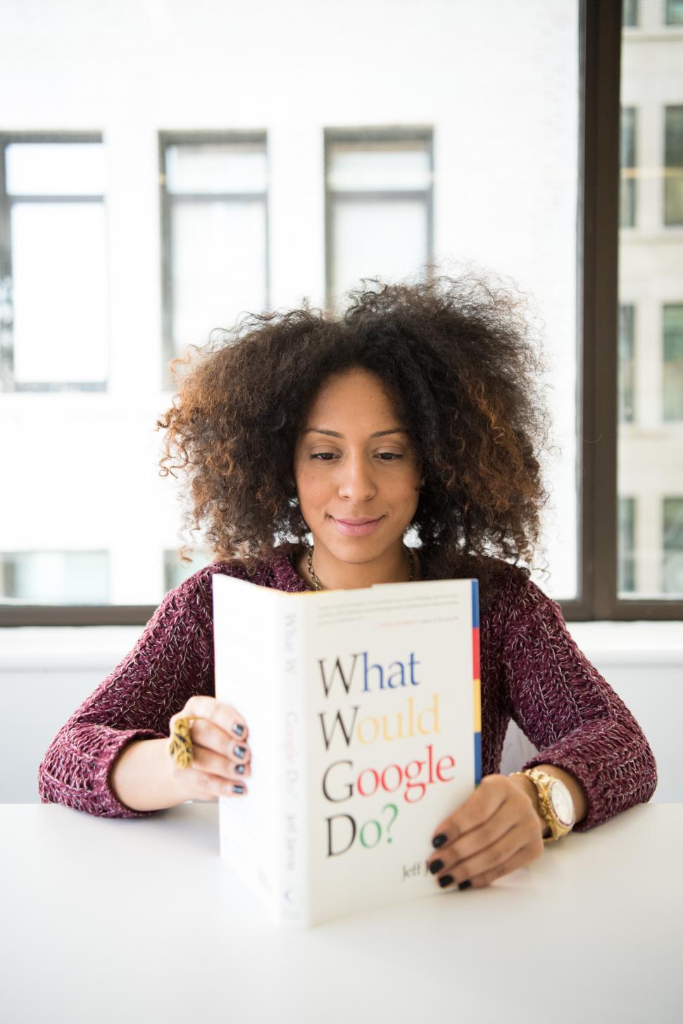 Free Image of Happy Female developer with book - looking down 