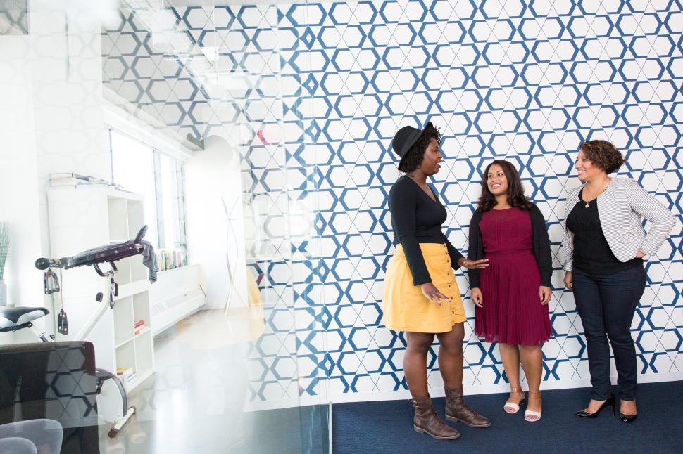 Free Image of Female co-workers talking and smiling in meeting room 