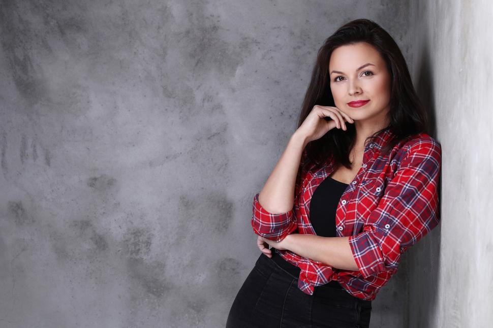 Free Image of Attractive woman leaning on a wall 