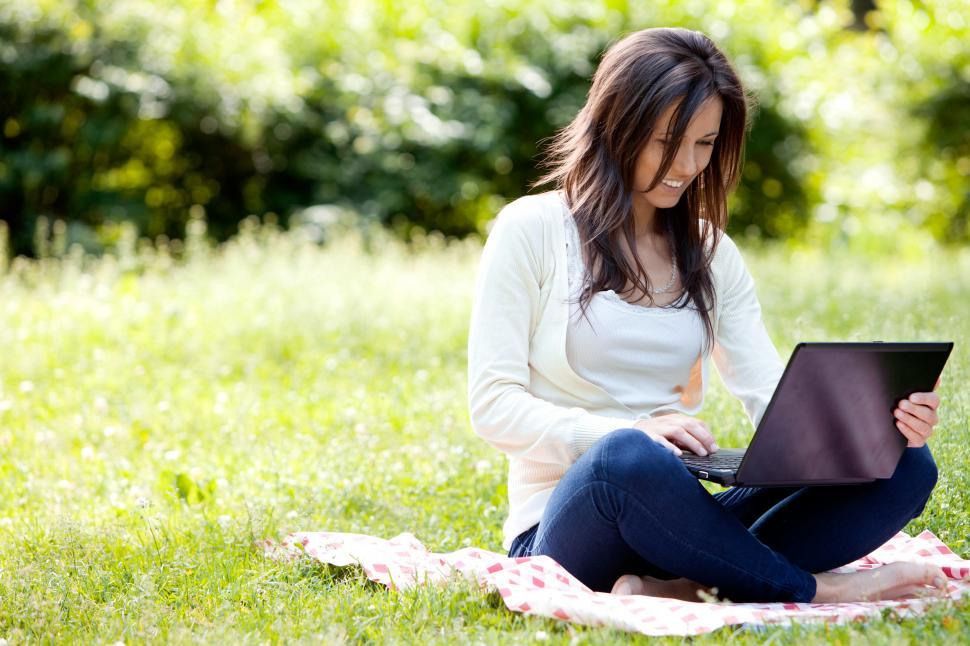 Young girl with laptop working outdoors