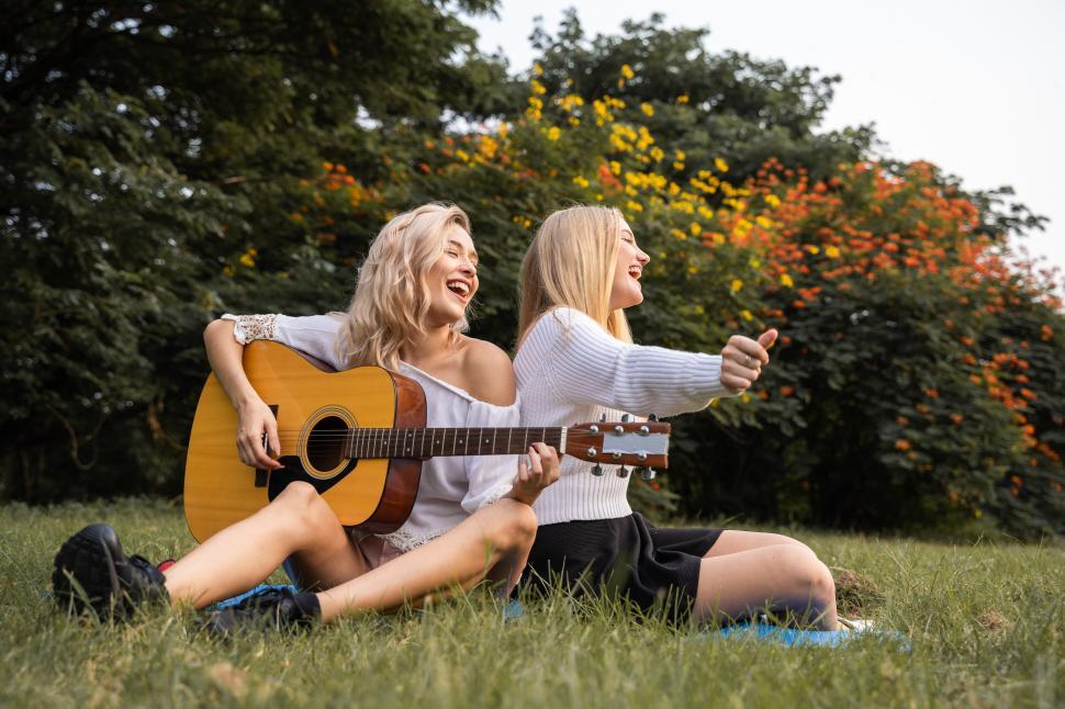 Free Image of Portrait of caucasian young women siging in the park 