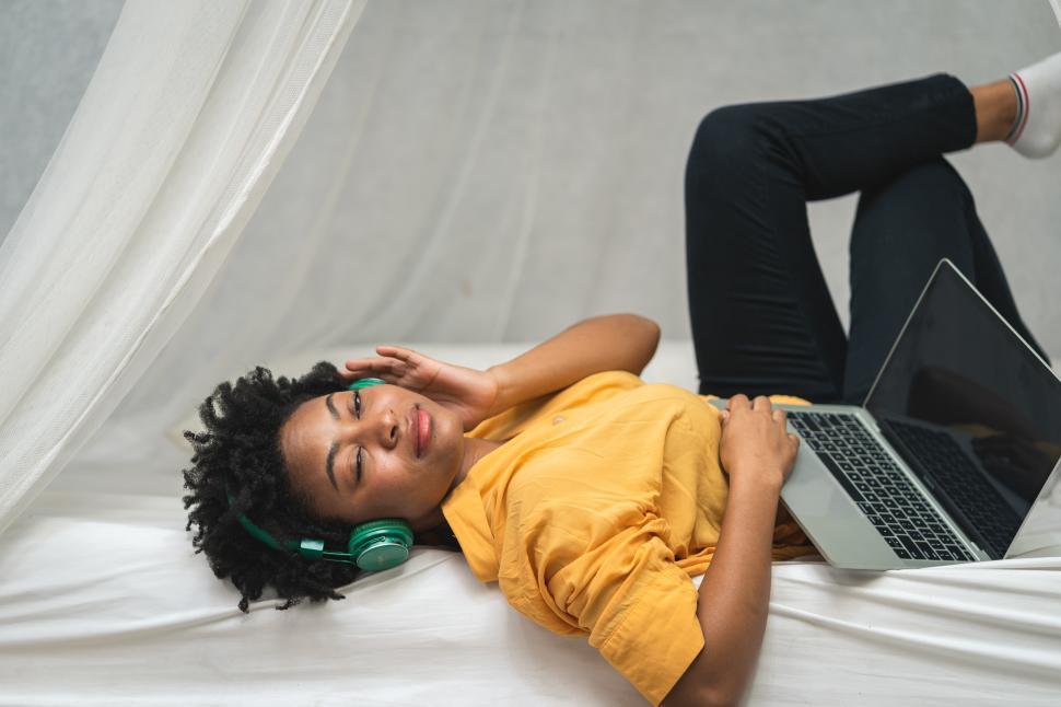 Free Image of woman in yellow shirt listening music with her headphones 