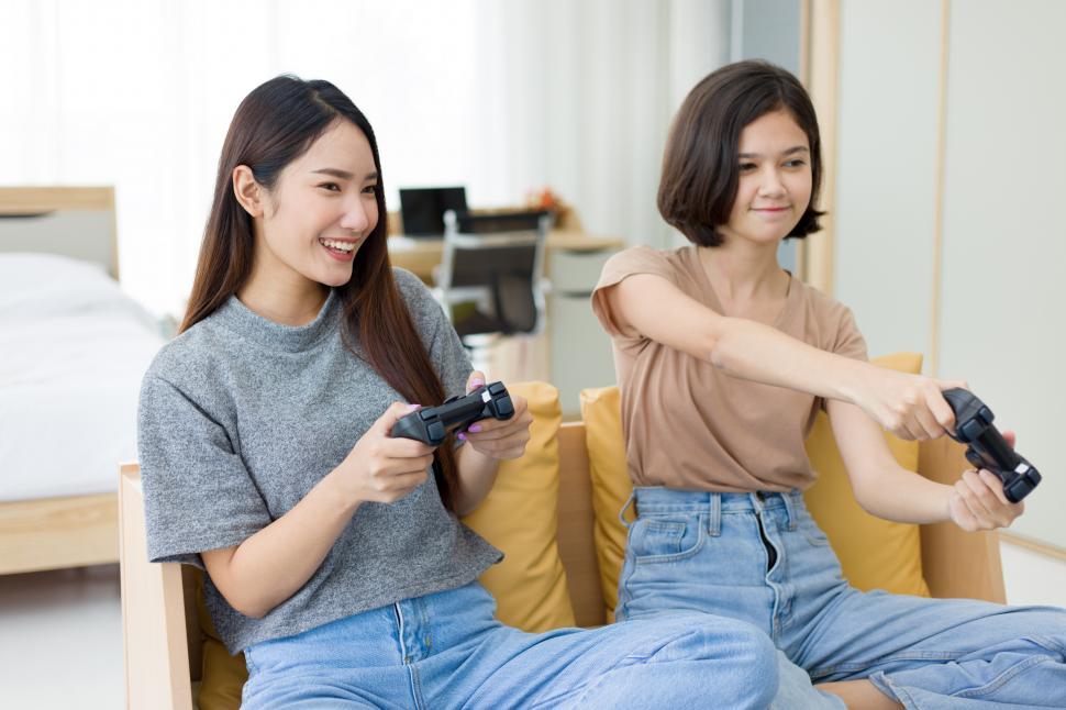 sexy Asian woman play game online on smartphone and smile Stock Photo