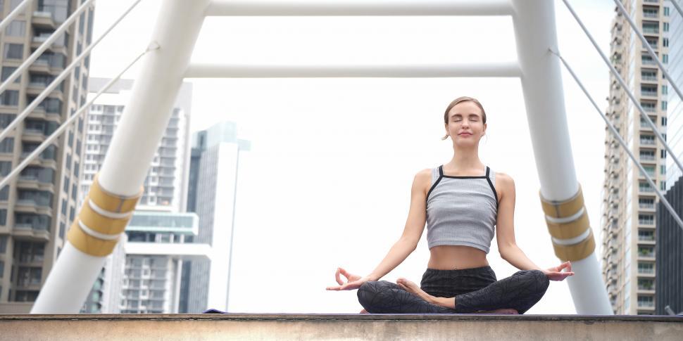 Free Image of Caucasian Woman is doing yoga exercise outdoors in modern setting 