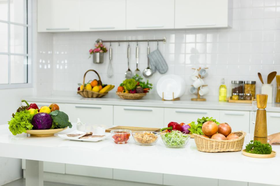 Fresh Fruits And Vegetables On Kitchen Table Stock Photo by