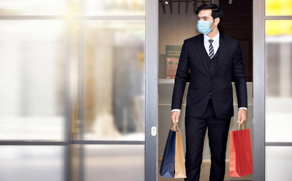 Free Image of Man in a suit carries a shopping bag 