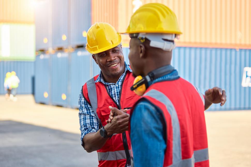 Free Image of Two transportation engineers shake hands, Say hello 