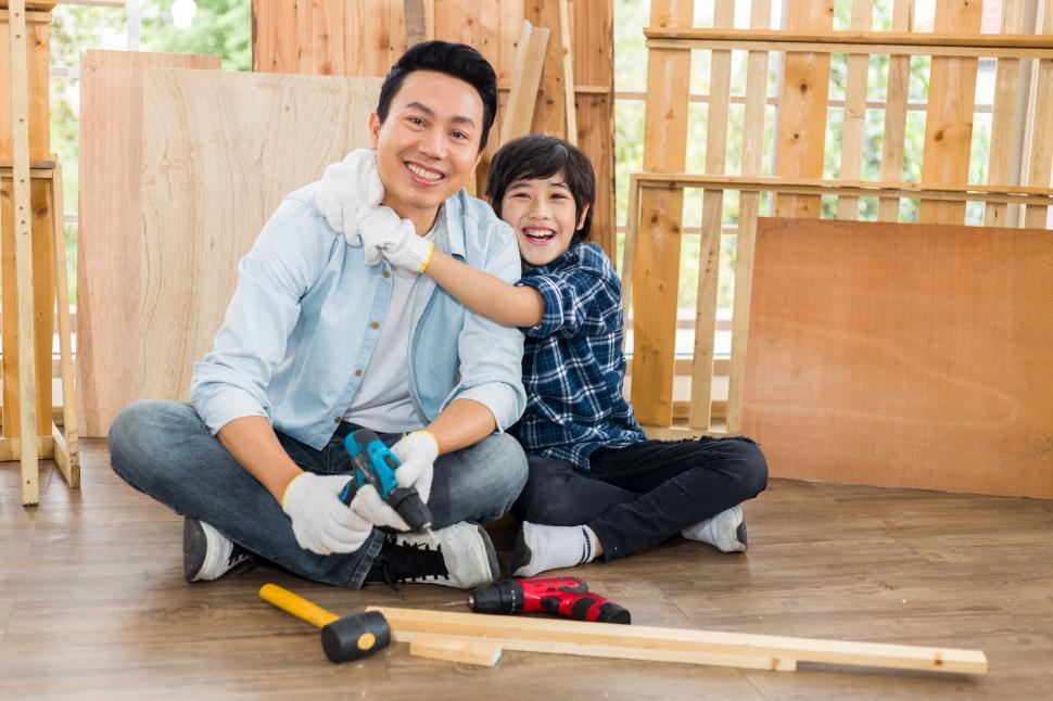 Free Image of Father and son happily helped to do woodwork at home. 