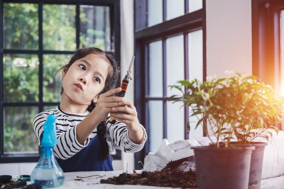 Free Image of Funny kid with tools and young plants 