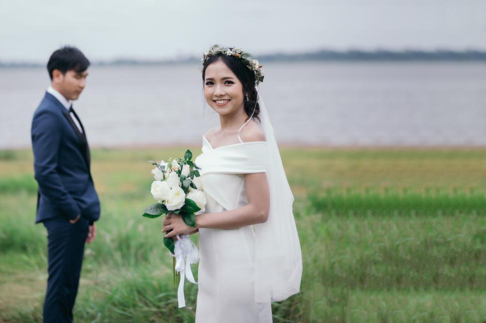 Free Image of Smiling bride holds a wedding bouquet in her hands 