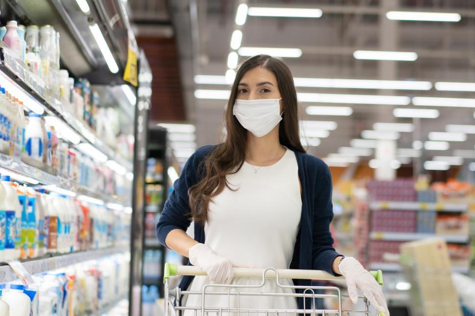 Free Stock Photo of Woman wearing medical mask and rubber glove shopping in  a grocery store